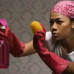 Mixed race housewife standing with cleaning supplies